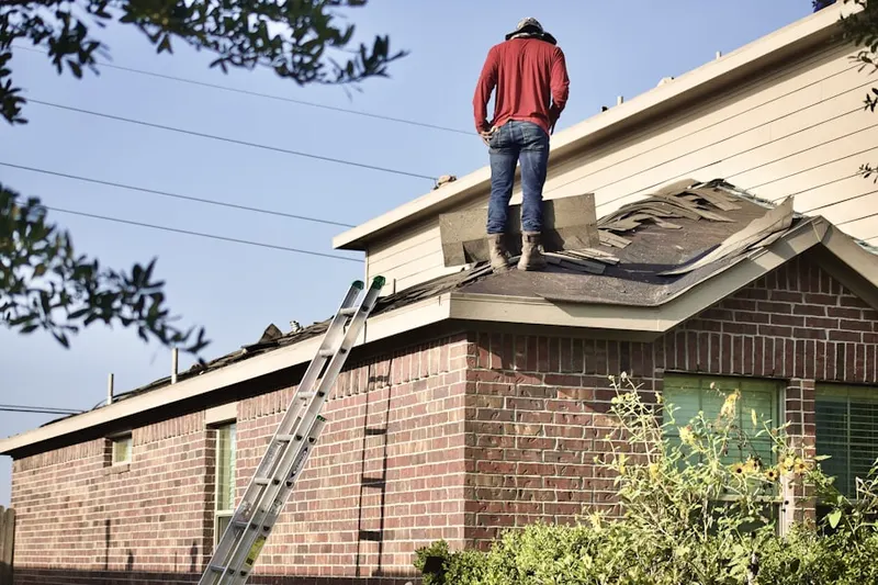Professional roofer working on a residential roof in Big Woods Estates